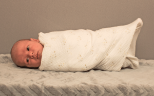 Want a calmer baby? Swaddling your baby is a GAME CHANGER! Here is how and why you should swaddle your baby! 