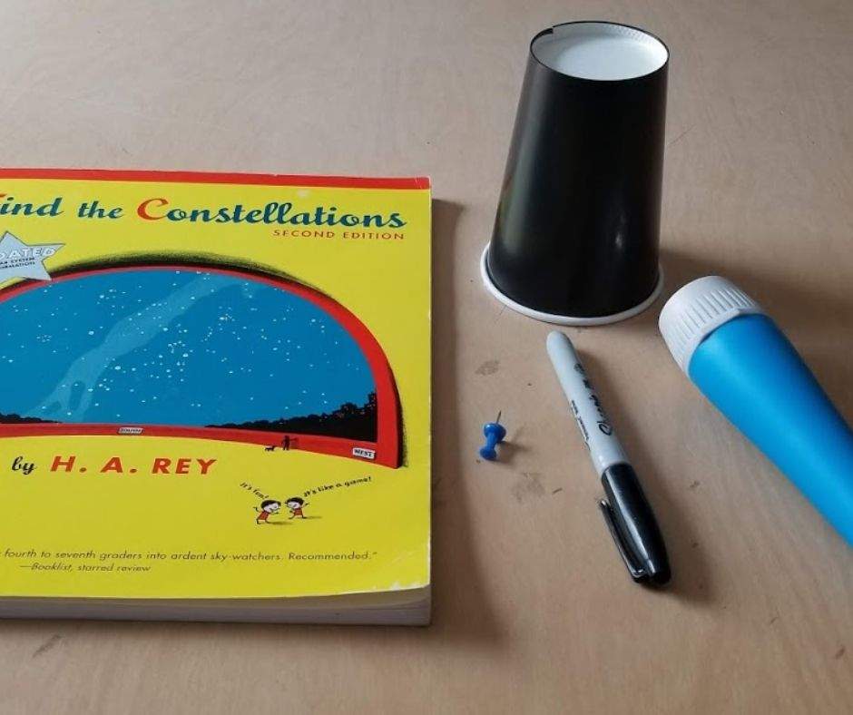 H.A. Rey's Find the Constellations, a paper cup, a marker, a push pin, and a flashlight