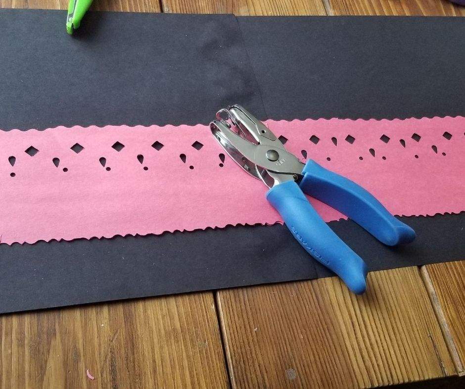 red construction paper decorated with hole punches to look resemble lace overlay