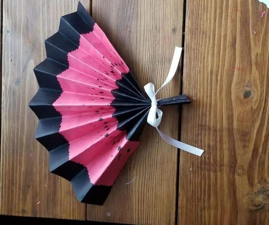 finished paper fan with ribbon tied on the handle